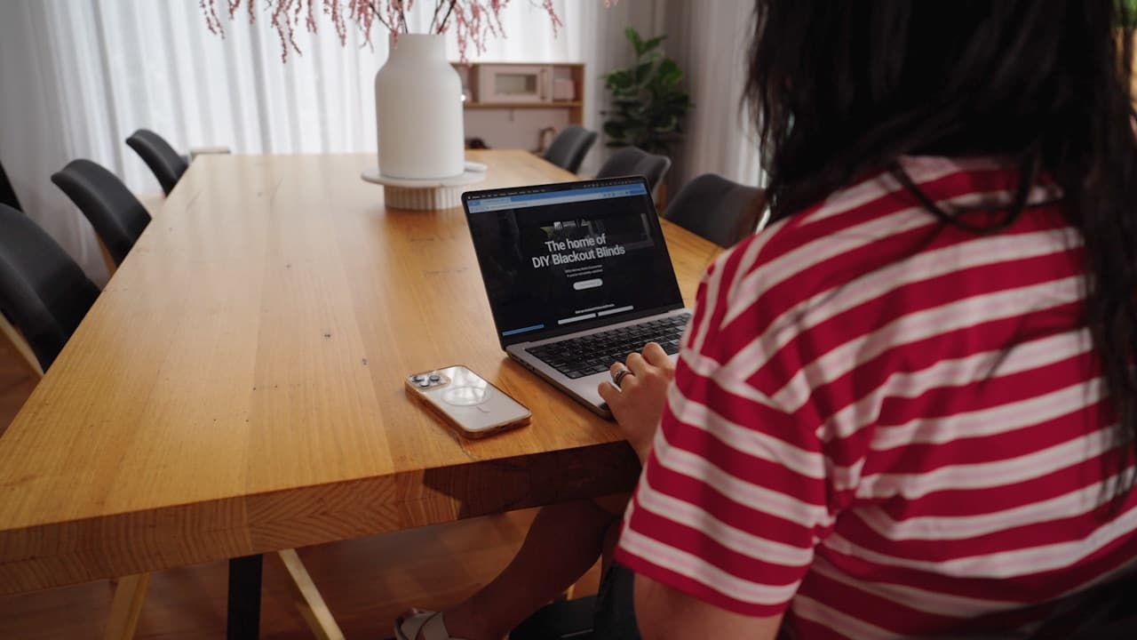 Customer configuring a blackout blind online at a laptop.