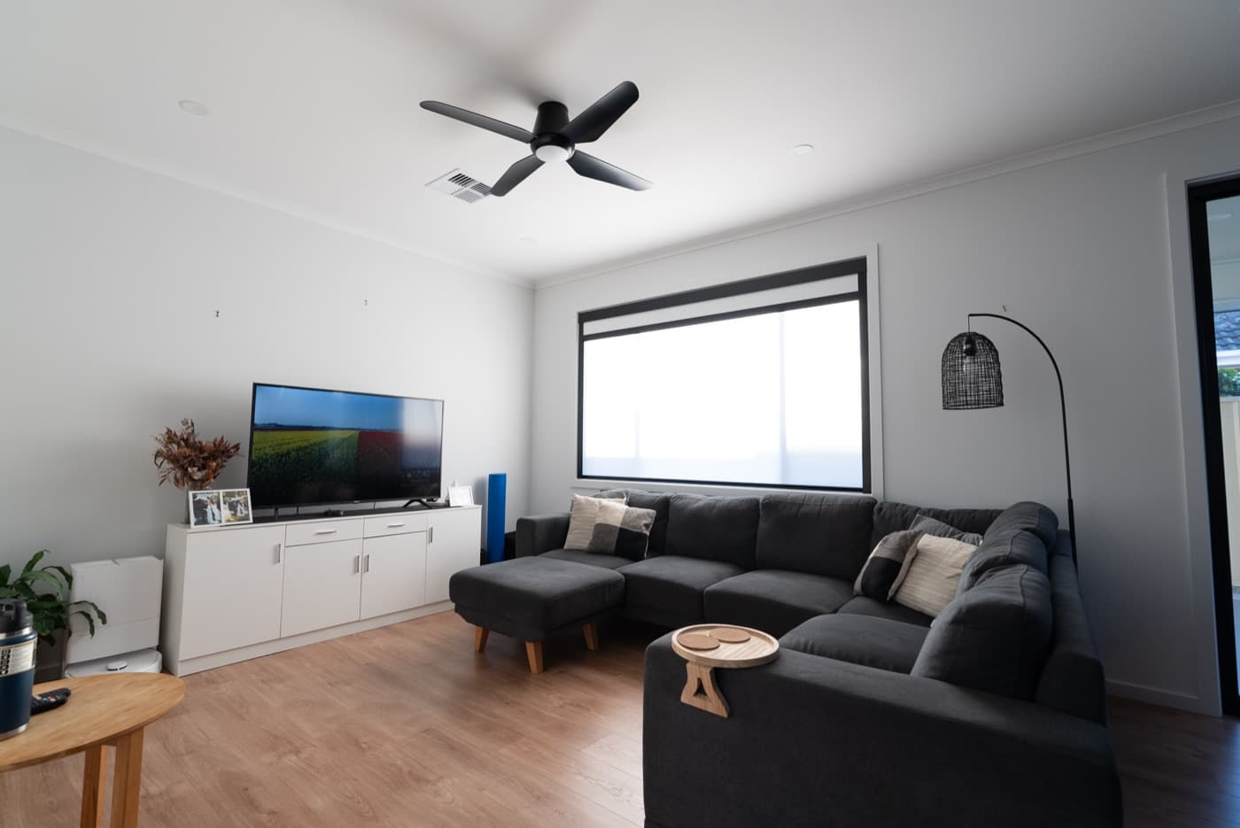 Day mode living room with the sheer blind down, soft daylight through the window.