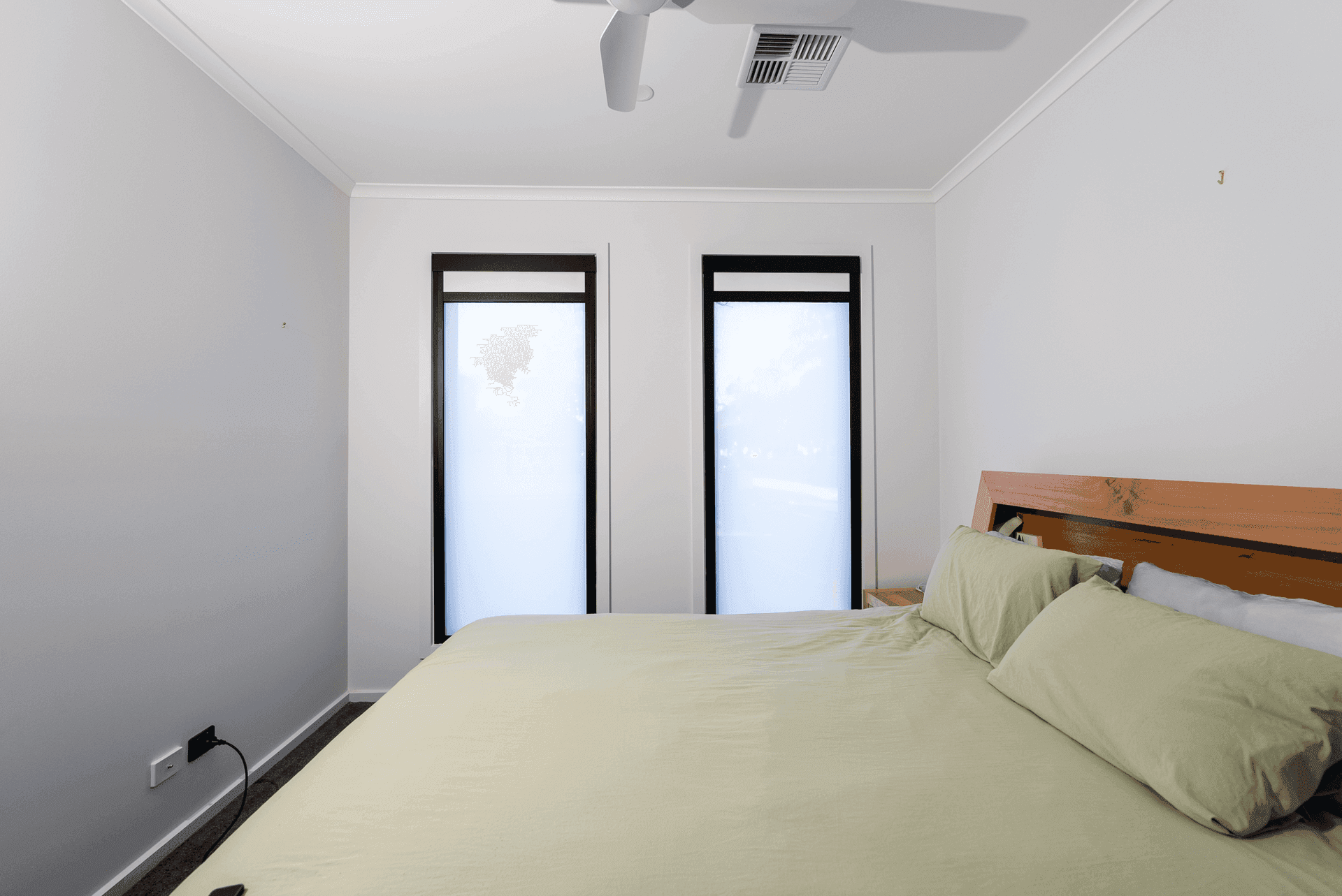 Black-frame motorised blackout blinds in an apartment bedroom.