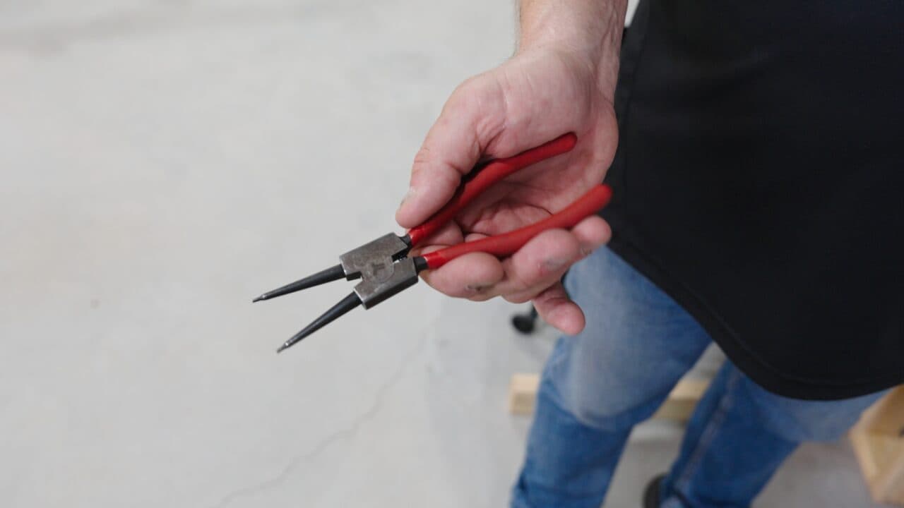 Photo: a circlip tool easing the side track open.