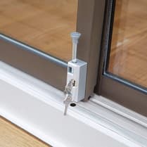 Sliding door lock with key, mounted on the door track.