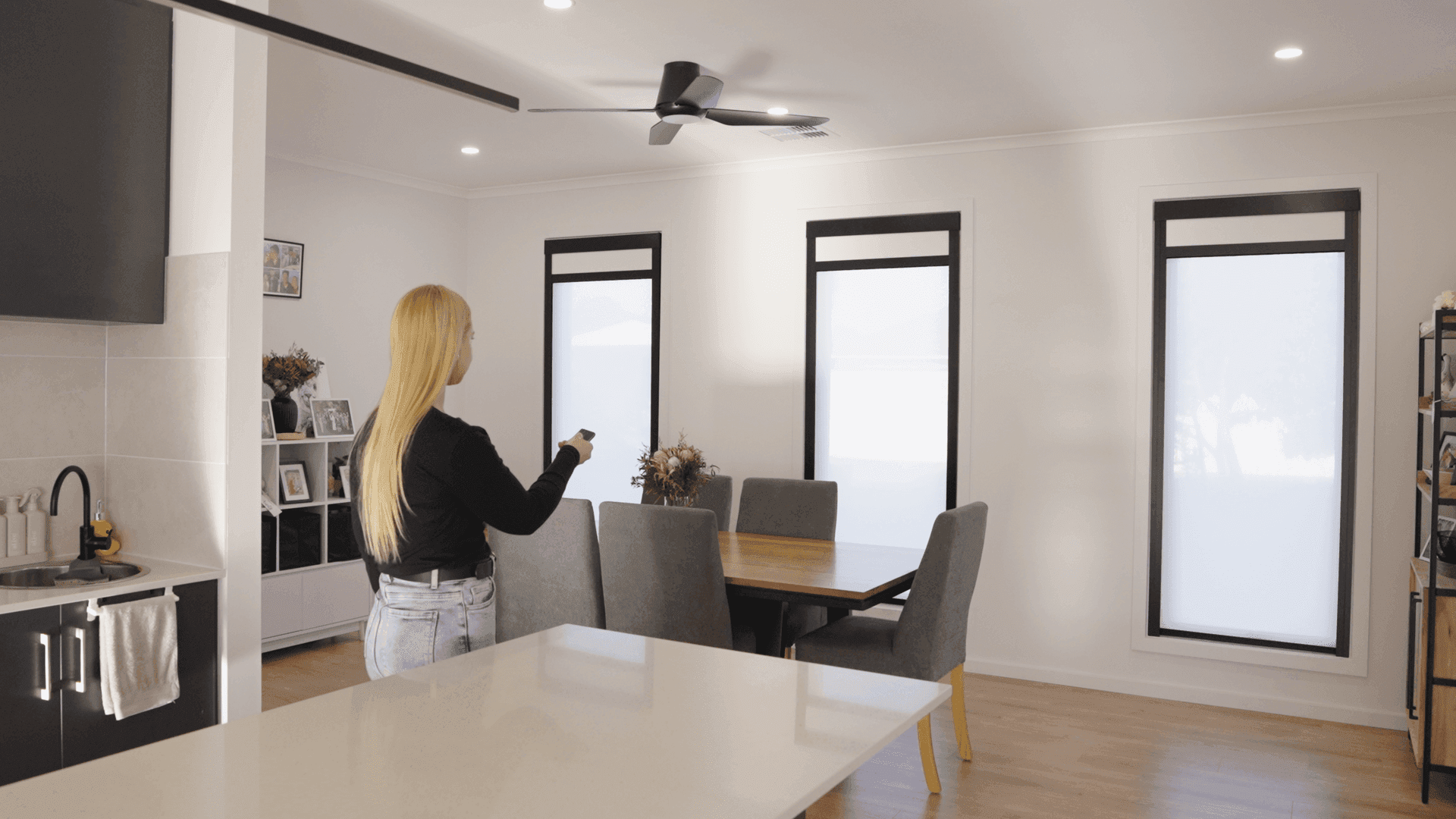 Open-plan living and dining area with tall blackout blinds.