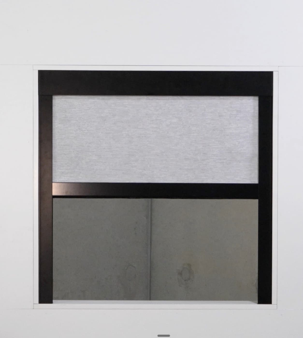Black aluminium side tracks and pelmet of a framed blind, blind part-lowered.